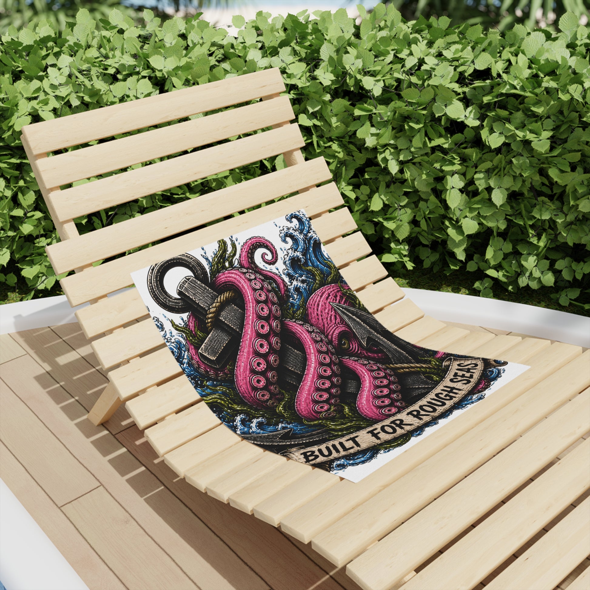 Nautical Kraken anchor beach towel on a wooden lounge chair, featuring a fuchsia octopus and 'Built for Rough Seas' design.