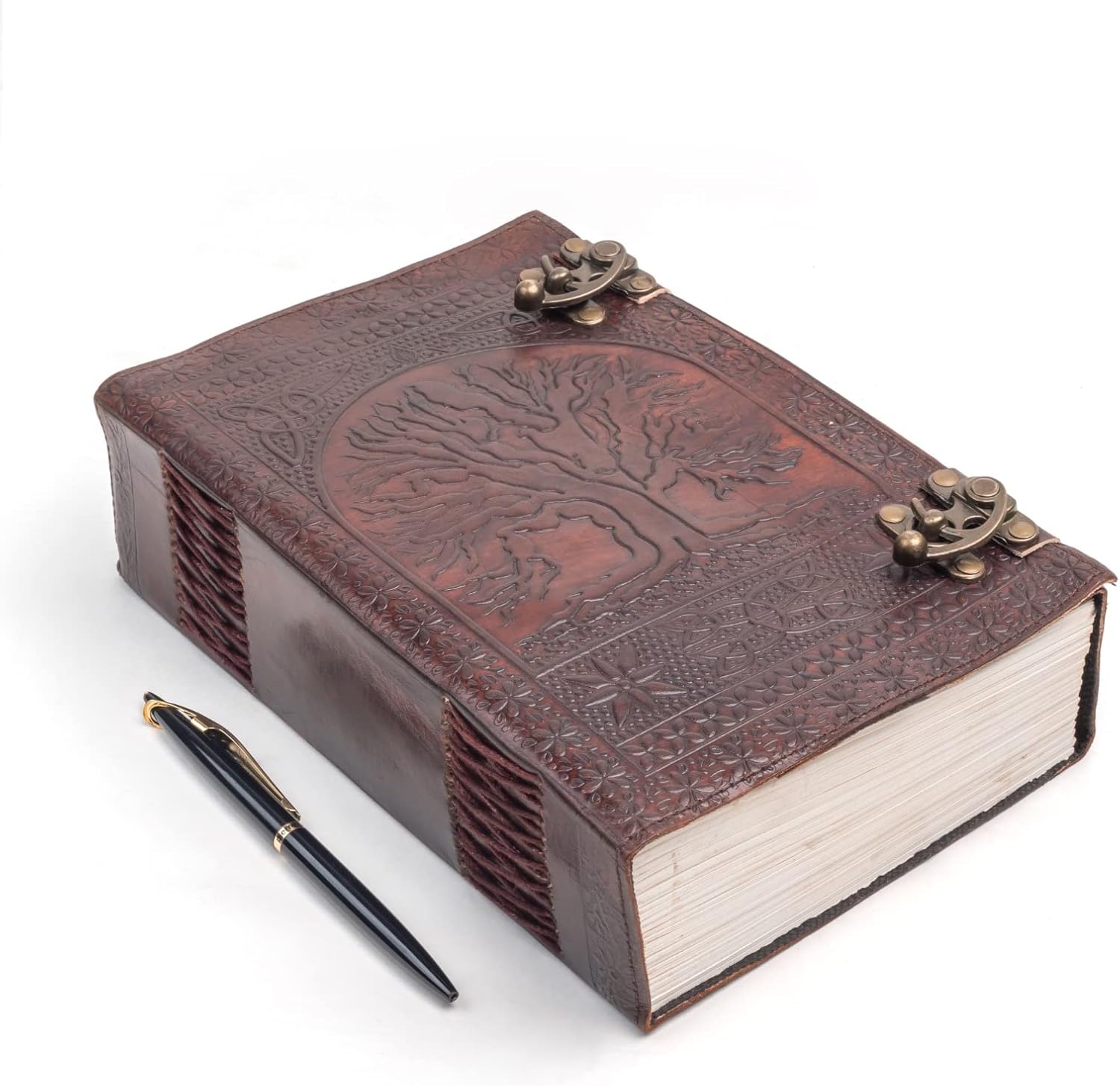 Brown handmade leather journal with embossed Tree of Life, brass C-locks, and hand-stitched binding beside a black pen.